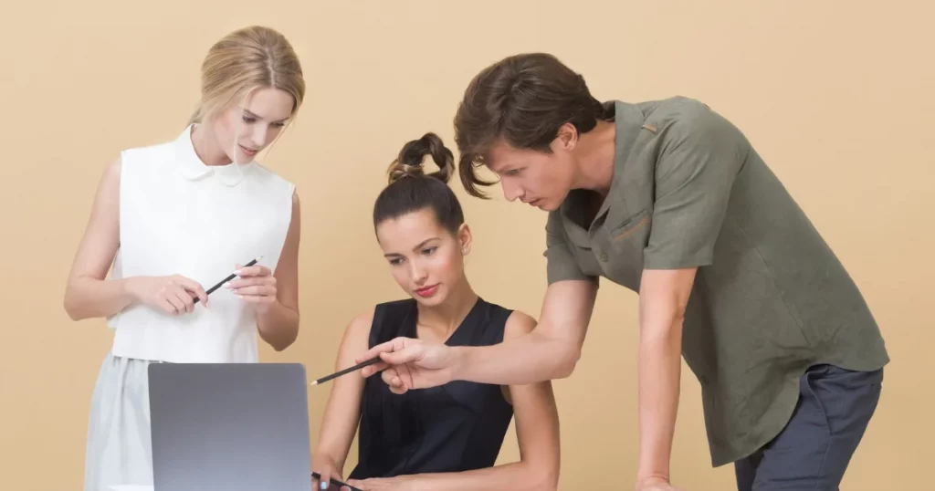 Agentforce Specialist study guide: a colleague walking a learner through Agentforce on a laptop
