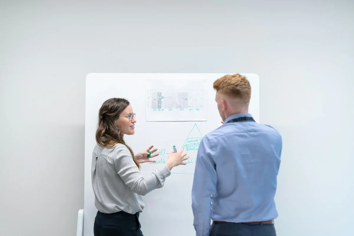 Salesforce implementation discovery: two colleagues mapping requirements on a whiteboard