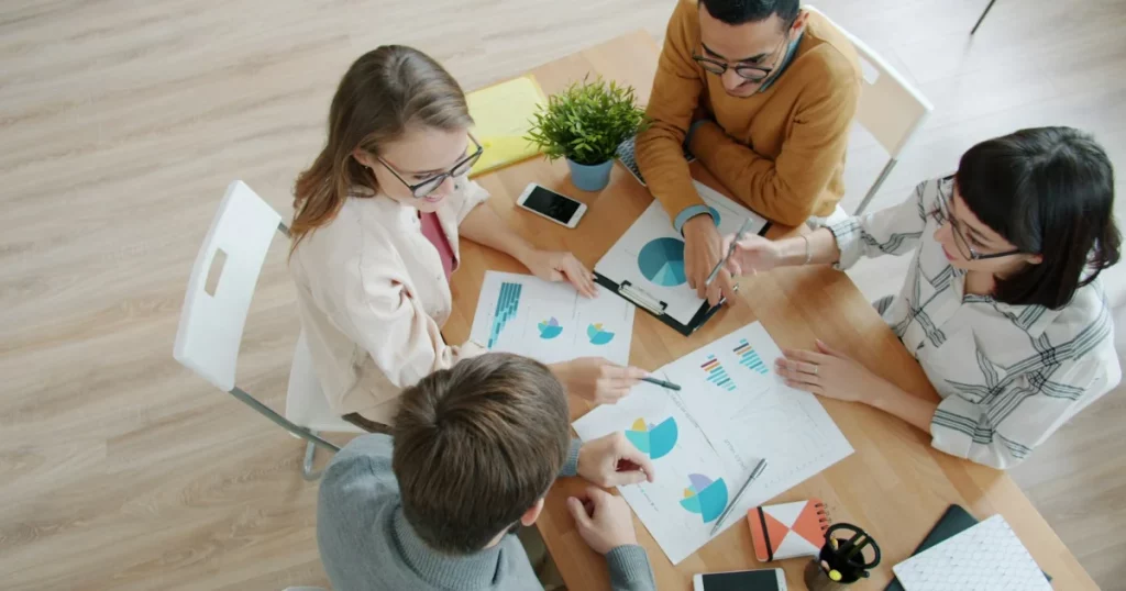 Salesforce implementation partner selection: a project team reviewing charts around a table